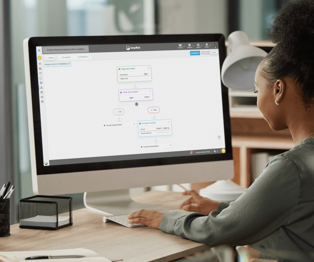 Woman at a desktop computer building an automation workflow in Leadfox