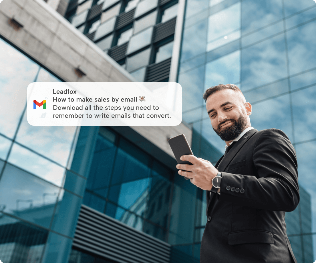 Man reading his phone beside a Leadfox email notification about making sales by email